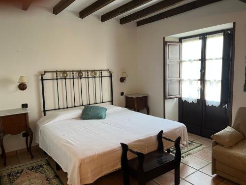 a bedroom with a bed and a chair and a window at Posada San Tirso in Toñanes