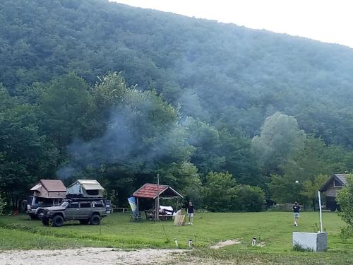 a truck parked in a field near a mountain at Kamp Suad in Bihać
