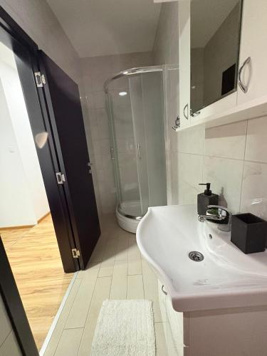 a bathroom with a white sink and a shower at Restoran,,Vuk,, Tršić in TrÅ¡iÄ‡