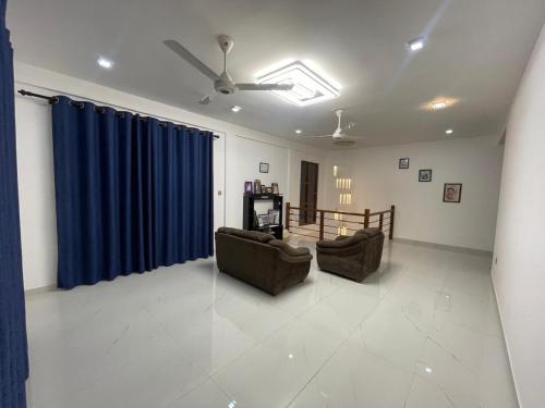 a living room with two couches and a blue curtain at EL Bethel House in Wattala