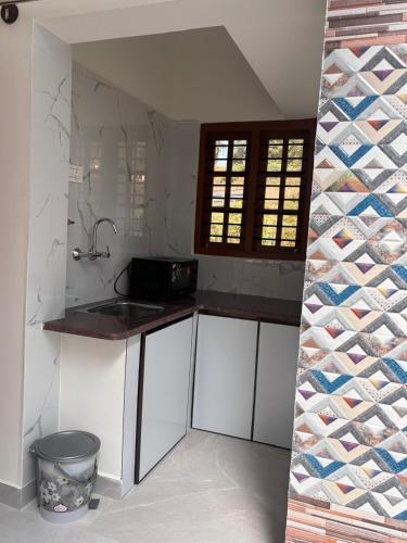 a kitchen with a sink and a wine rack at R's Bolli Kudike in Madikeri