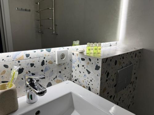 a bathroom with a sink and a mirror at GS Green Apartment in Starokostyantyniv