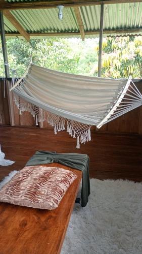 a bed with a hammock in a room at Cabaña lago Río Celeste in El Achiote