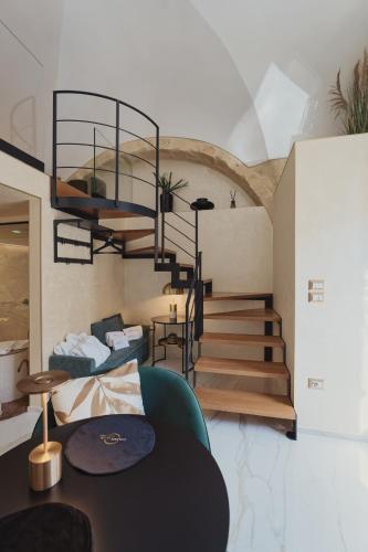 a living room with a spiral staircase and a table at Golden Suite in Stornarella
