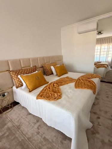 a bedroom with a large white bed with yellow pillows at Casa São Domingos 2 in Lousada