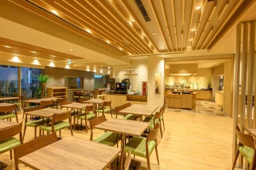 a restaurant with wooden tables and chairs and a kitchen at Dormy Inn Premium Ginza - Natural Hot Spring in Tokyo