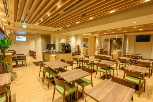 an empty restaurant with wooden tables and chairs at Dormy Inn Premium Ginza - Natural Hot Spring in Tokyo