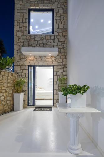 a room with a stone wall and a door with potted plants at Dion Villa Zakynthos Greece in Zakynthos