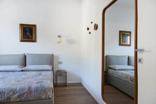 a mirror in a room with a bed and a bed sidx sidx sidx at Rhapsody on the Lake in Lezzeno