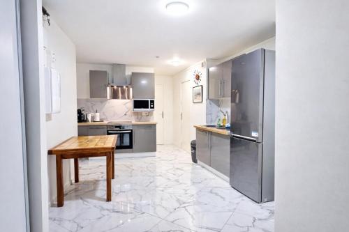 a kitchen with stainless steel appliances and a wooden table at Paris & Disney - 5 mins from Train Station - Champs Harmony in Champs-sur-Marne