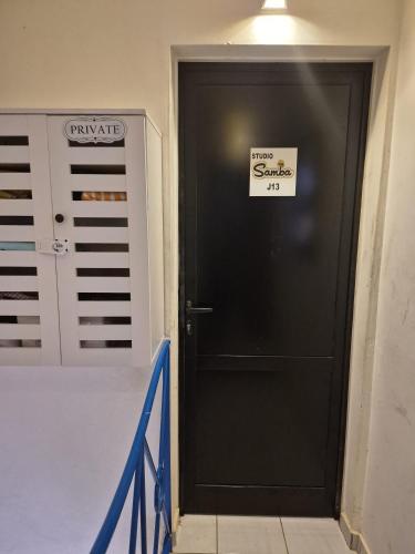 una porta nera con un cartello in una stanza di Studio Samba a Saly Portudal