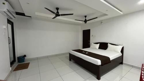 a bedroom with a bed with a ceiling fan at Gravity Groups Golden Residency in Puducherry Airpoert