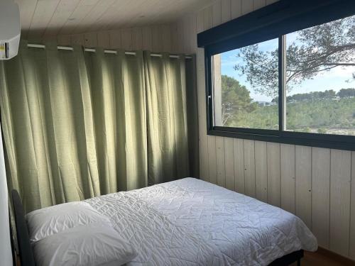 a bedroom with a bed and a window at Chalet Ali Vue panoramique in Le Castellet