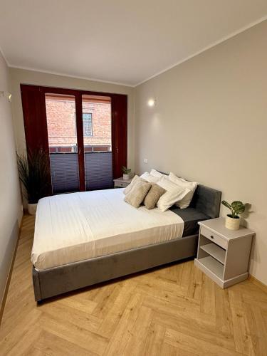 a bedroom with a large bed and a night stand at Vallikraavi Old Town Apartment in Tartu