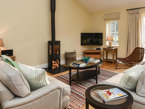 a living room with a couch and a fireplace at Beaufort Dairy in Pulborough