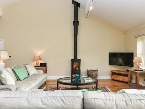 a living room with a couch and a fireplace at Beaufort Dairy in Pulborough