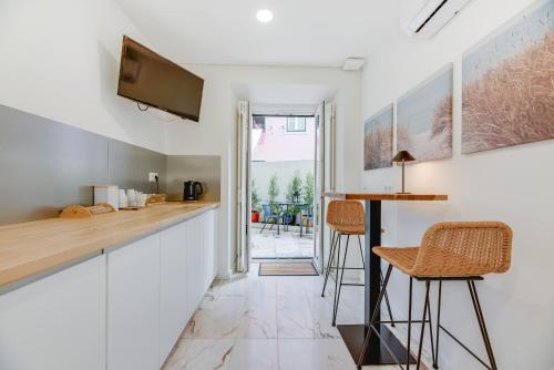 a kitchen with a bar and stools in a room at Correio Velho Hotel in Lisbon