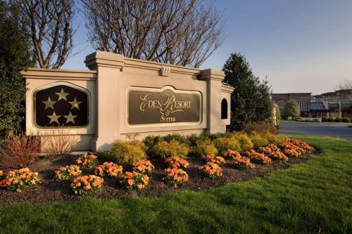 a sign for a hotel with flowers in a yard at Eden Resort and Suites, BW Premier Collection in Lancaster