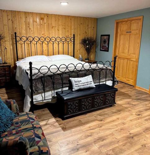 a bedroom with a large bed and a wooden floor at Brandy Bay Hideaway: Pet Friendly Retreat in Arbor Vitae