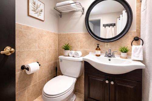 a bathroom with a toilet and a sink and a mirror at Plush & Spacious 2-Bedroom in NYC in New York