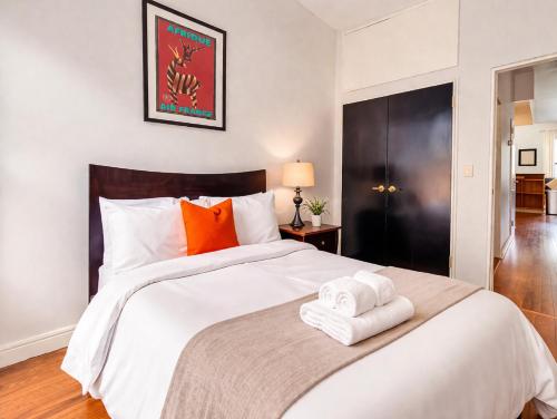 a bedroom with a large white bed with towels on it at Plush & Spacious 2-Bedroom in NYC in New York