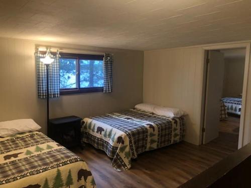 a bedroom with two beds and a window at Gresham Shores - Big Dipper - PET FRIENDLY in Arbor Vitae