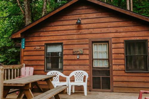 a wooden cabin with a picnic table and chairs at Old Stoney's Walleye- Pet Friendly in Arbor Vitae