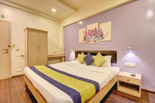 ein Schlafzimmer mit einem großen Bett in einem Zimmer in der Unterkunft MY Bizz Hotel Sapna in Pune