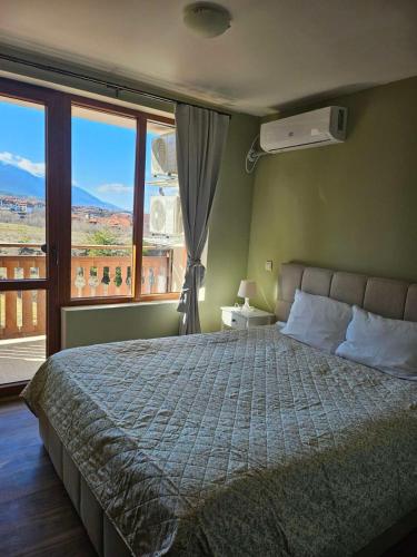 a bedroom with a bed and a large window at Panorama View in Bansko