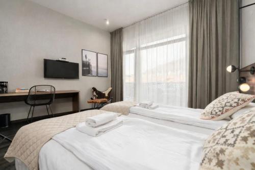a bedroom with a large white bed with a window at Lake Hill Studio 35- strefa wellness w cenie in Sosnówka