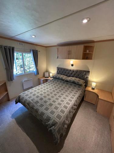a bedroom with a large bed and two night stands at Bailey's Caravan Hire - Sealands Plot 1 - Wi-Fi - Dog Friendly in Ingoldmells