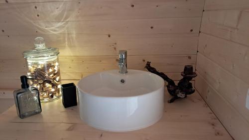 a bathroom with a white sink and a glass jar at Tonneau Bourgignon in Le Rousset
