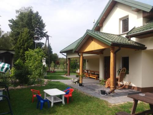 a patio with a gazebo next to a house at Agroturystyka Leśna Malinka in Celejów