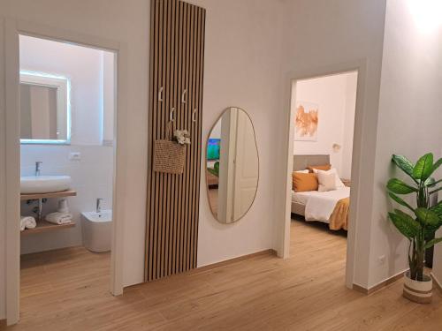 a bathroom with a mirror and a bedroom with a bed at Lo Spaho Suite Florence in Florence