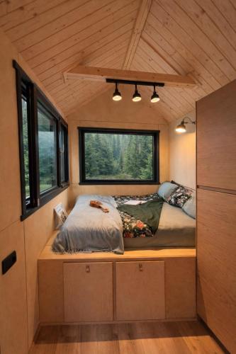 a bed in the middle of a tiny house at Tiny House Retreat Mountain View Bicazul Ardelean in Bicazu Ardelean