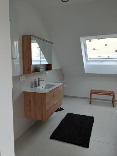 a bathroom with a sink and a mirror and a window at Ferienwohnung Hagebutte in Bad Bocklet