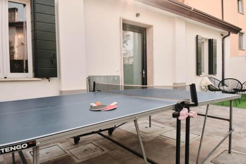 a ping pong table in front of a building at Ortensie House in Padova