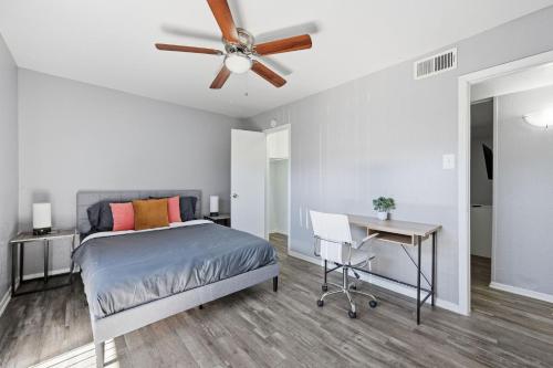 a bedroom with a bed with a ceiling fan and a desk at Great 1BR Mid-Term Apartment in Denton