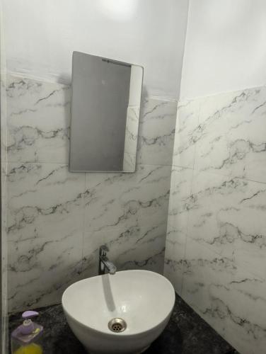 a white sink in a bathroom with marble walls at Rahatani pimple Saudagar 2bhk in Chinchwad