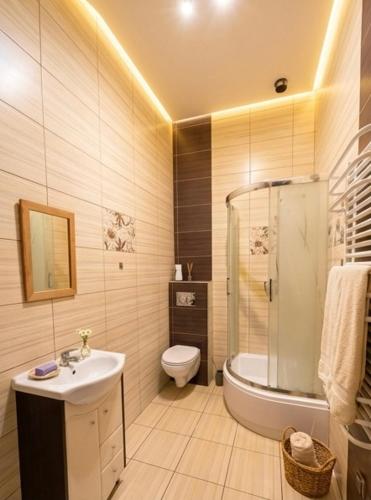 a bathroom with a sink and a toilet and a shower at Agro nad jeziorem in Miastko