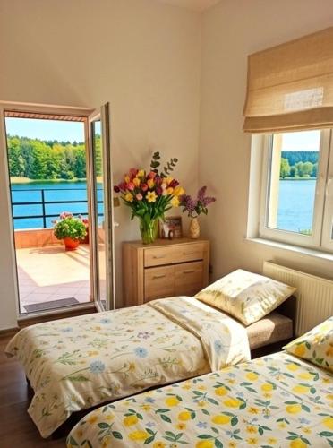 a bedroom with two beds and a vase of flowers at Agro nad jeziorem in Miastko