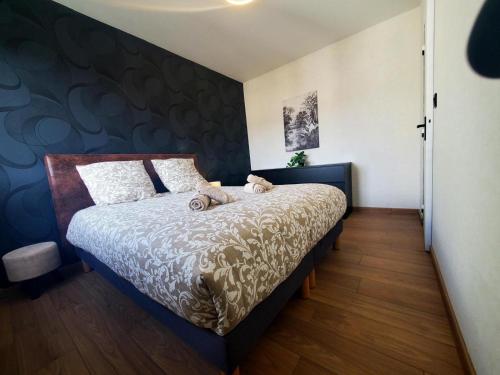 a bedroom with a bed with a blue accent wall at Le Cocon Clermontois - T2 Centre in Clermont-Ferrand