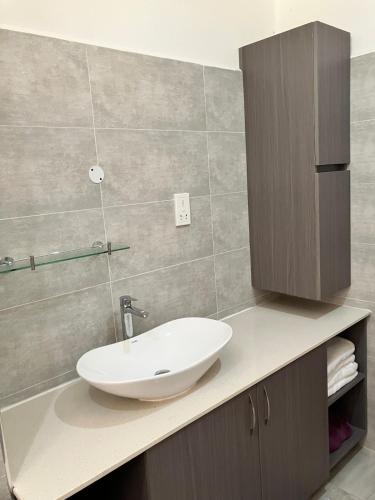 a bathroom with a white sink on a counter at Villa Maria Anse Corail in Takamaka