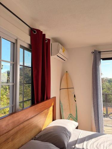 a bedroom with a surfboard on the wall next to a bed at Altos de Santa Catalina in Soná