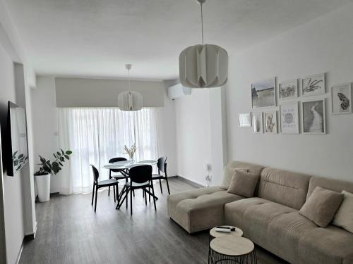 a living room with a couch and a table and chairs at Beach apartments in Limassol