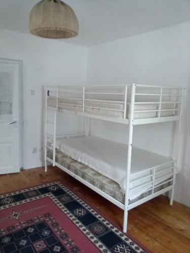 a white bunk bed in a room with a rug at Grădina Zoriza in Buzău