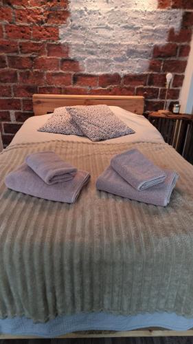 two beds with towels sitting on top of them at Cozy Studio in Kouvola