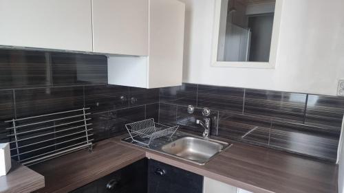 a kitchen counter with a sink and a mirror at Cozy Studio in Kouvola