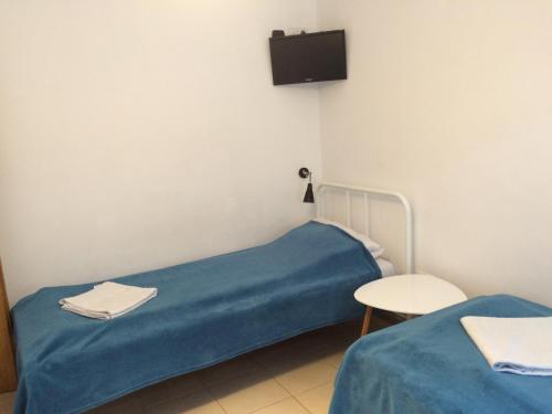 a hospital room with a blue bed and a chair at Retro Hostel in Cluj-Napoca