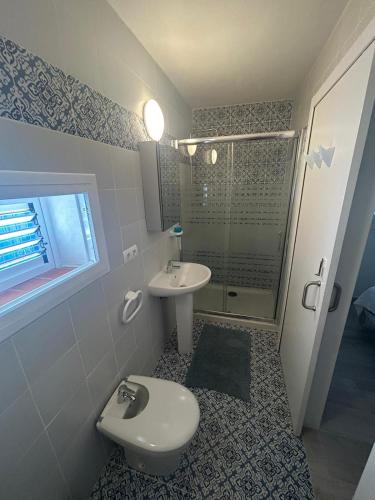 a bathroom with a toilet and a sink and a shower at Can Fede in Cala Tarida